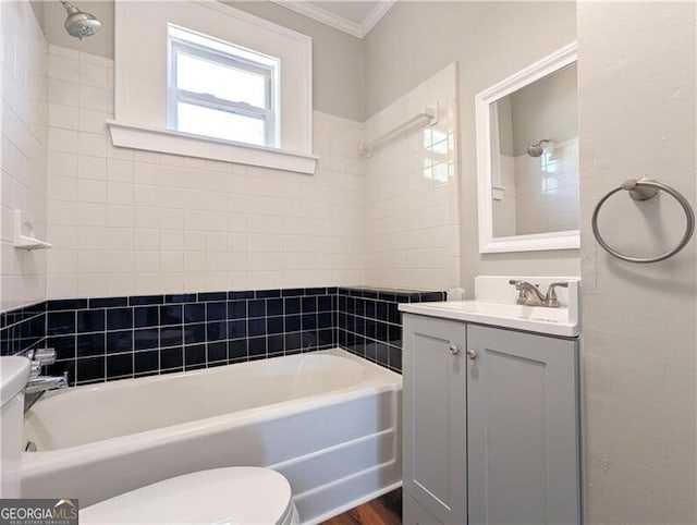 full bath with toilet, vanity, ornamental molding, and washtub / shower combination