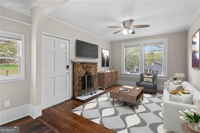 living room featuring crown molding, a ceiling fan, plenty of natural light, and wood finished floors