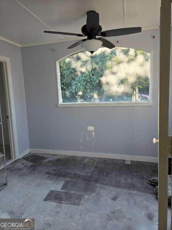 spare room featuring baseboards, ceiling fan, and crown molding