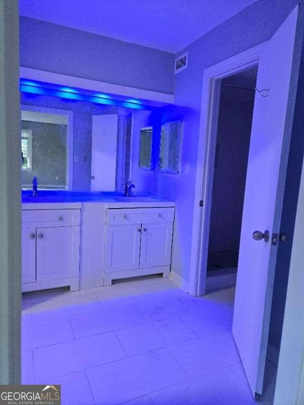full bath featuring a sink, visible vents, and double vanity