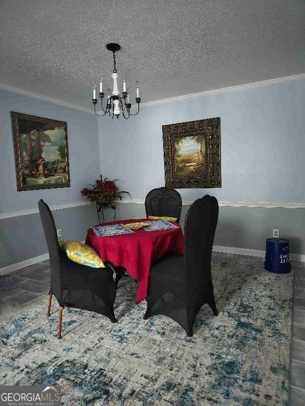 dining area with an inviting chandelier, baseboards, and a textured ceiling