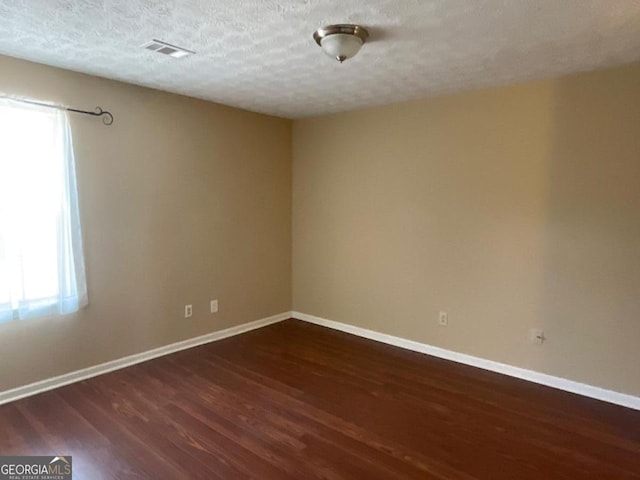 empty room with plenty of natural light, baseboards, and dark wood-style flooring