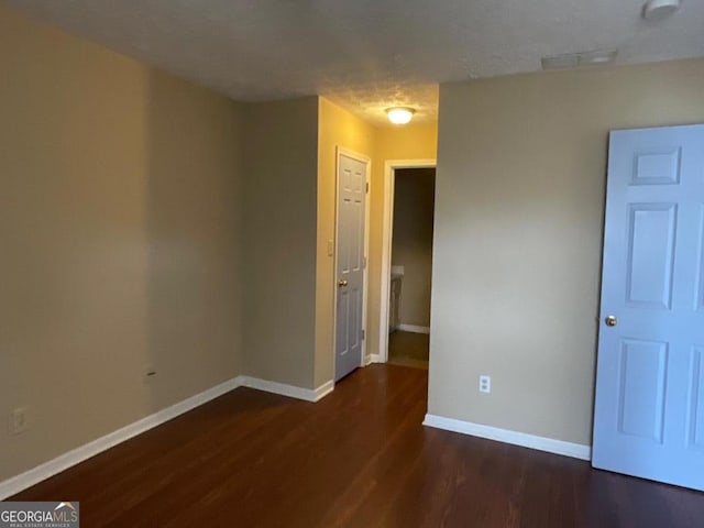 spare room featuring visible vents, baseboards, and wood finished floors