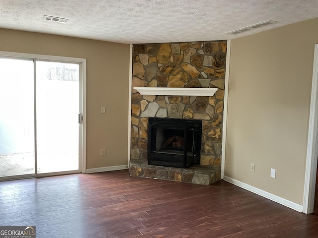 unfurnished living room featuring wood finished floors, visible vents, and a textured ceiling