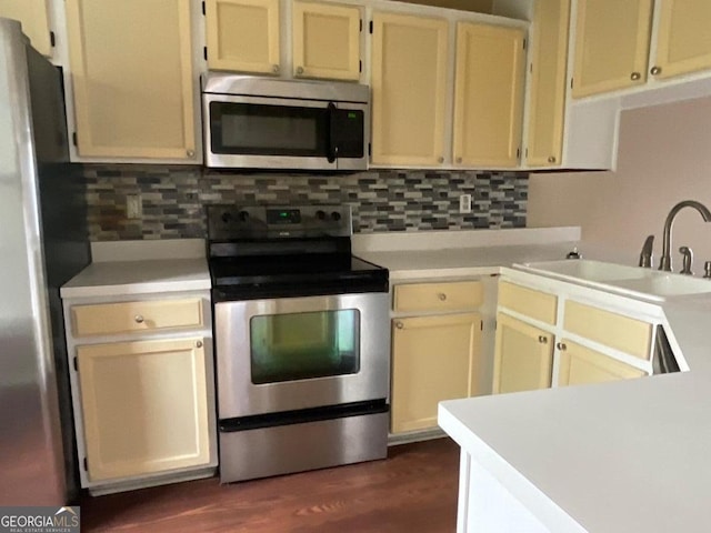 kitchen featuring stainless steel appliances, light countertops, and a sink