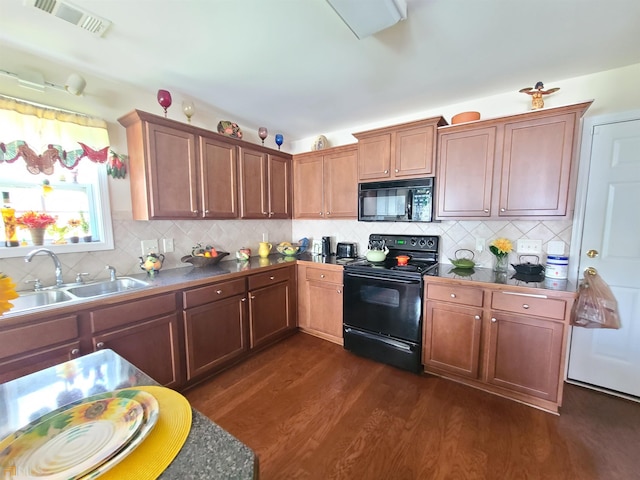 kitchen featuring backsplash, a sink, dark wood-style floors, visible vents, and black appliances