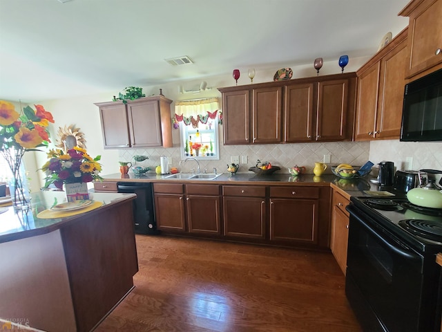 kitchen featuring dark wood-type flooring, decorative backsplash, a sink, visible vents, and black appliances