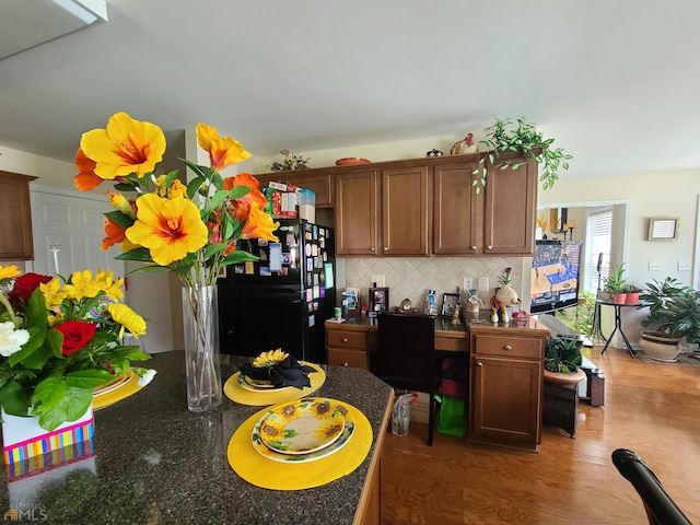 kitchen with wood finished floors, freestanding refrigerator, and tasteful backsplash