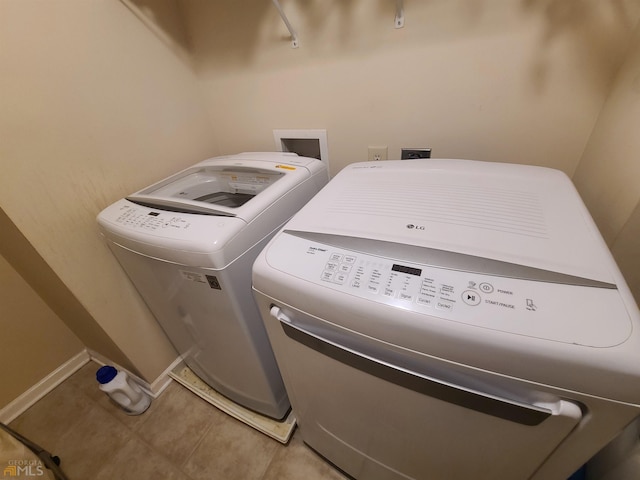 laundry room featuring independent washer and dryer, baseboards, tile patterned flooring, and laundry area