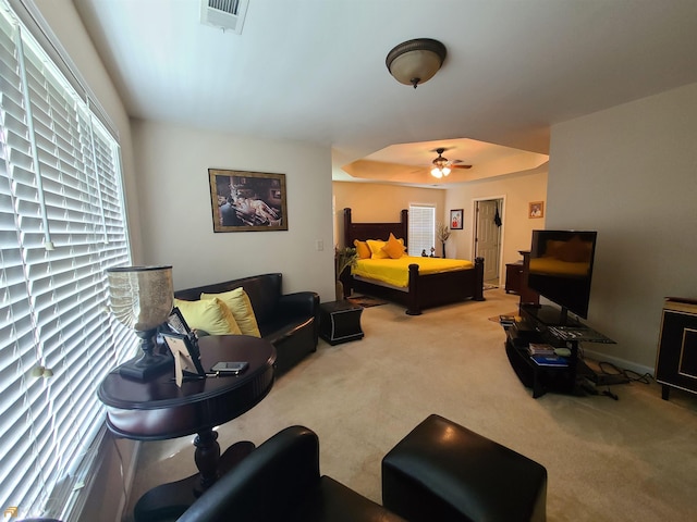 bedroom with visible vents, carpet flooring, and a raised ceiling