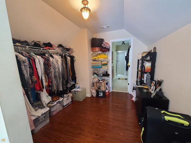 spacious closet featuring visible vents, lofted ceiling, and wood finished floors