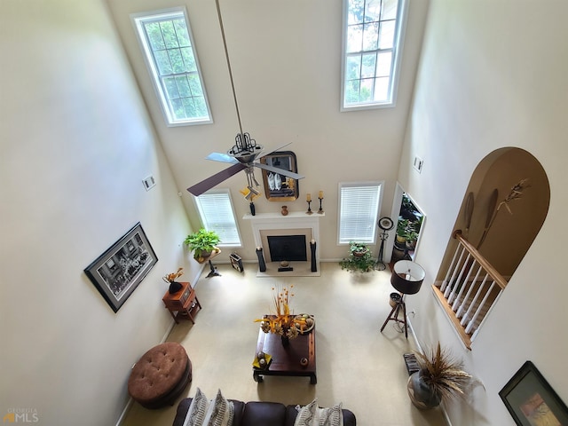 living room with a fireplace, a towering ceiling, and stairway