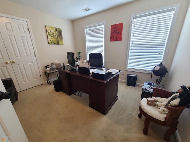 office space featuring light carpet, baseboards, and visible vents