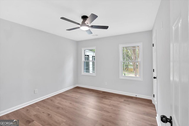 spare room featuring baseboards, a ceiling fan, and wood finished floors