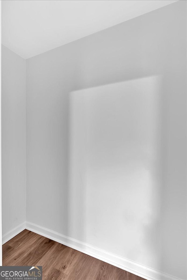 empty room featuring baseboards and wood finished floors