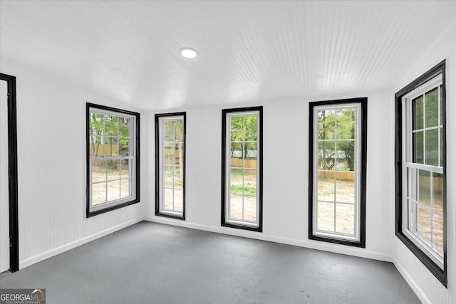 empty room featuring baseboards and finished concrete flooring