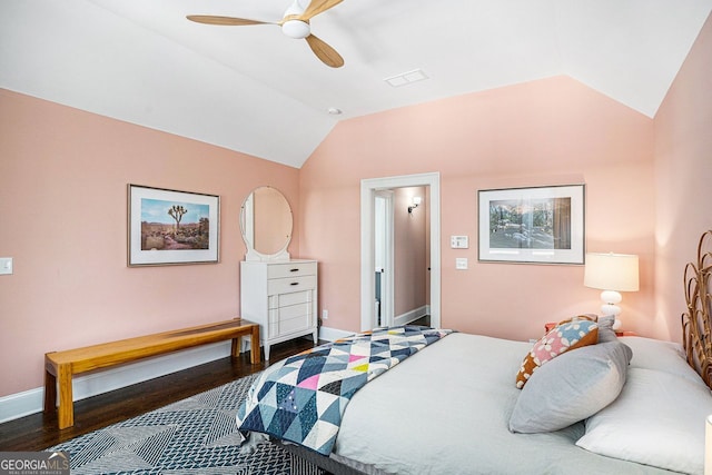 bedroom featuring baseboards, vaulted ceiling, and wood finished floors