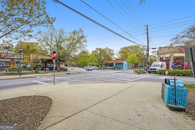 view of road with traffic signs, sidewalks, and street lighting