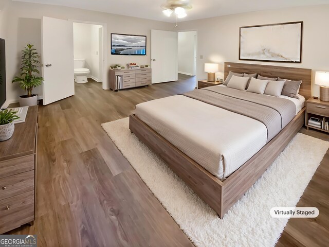 bedroom with ensuite bath and wood finished floors