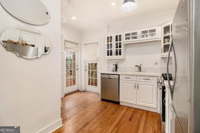 650 Somerset Ter NE, Atlanta, GA 30306 - kitchen featuring light countertops, crown molding, white cabinetry, stainless steel appliances, and light wood-style flooring