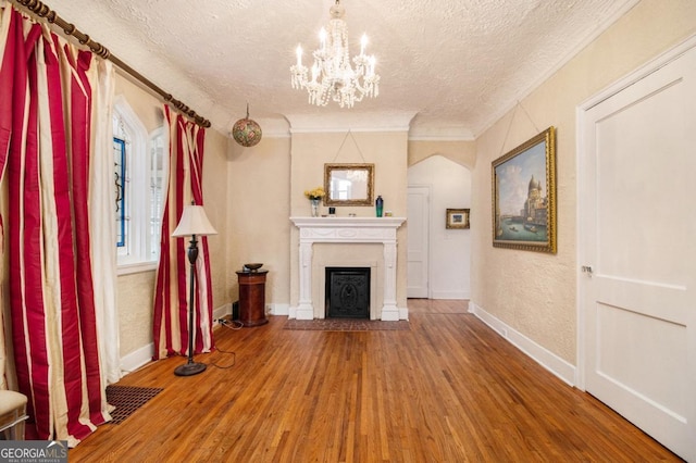 650 Somerset Ter NE, Atlanta, GA 30306 - unfurnished living room with crown molding, visible vents, wood finished floors, and a textured ceiling