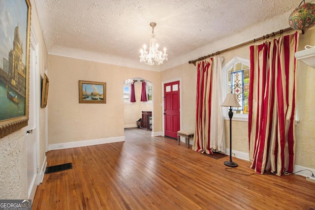 650 Somerset Ter NE, Atlanta, GA 30306 - empty room with a wealth of natural light, arched walkways, wood finished floors, and a textured ceiling