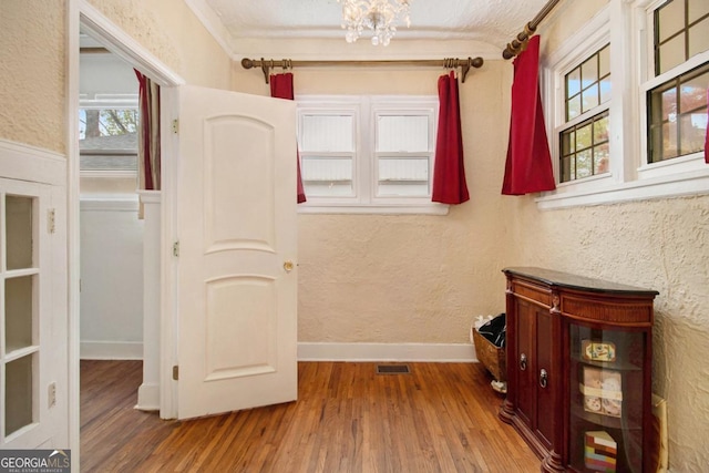 650 Somerset Ter NE, Atlanta, GA 30306 - corridor with wood finished floors, a chandelier, a textured wall, and crown molding