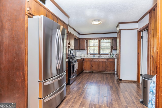 310 Austin Rd, Newnan, GA 30263 - kitchen with stainless steel appliances, dark wood-style floors, a textured ceiling, crown molding, and light countertops