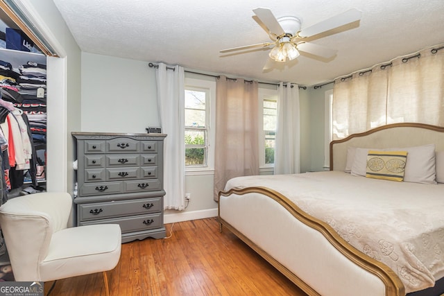 310 Austin Rd, Newnan, GA 30263 - bedroom with light wood-type flooring, baseboards, a walk in closet, a closet, and a ceiling fan