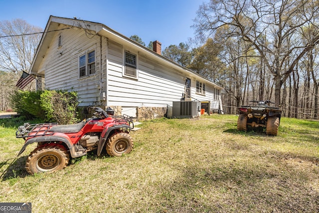 310 Austin Rd, Newnan, GA 30263 - back of house with a chimney, a lawn, and central AC
