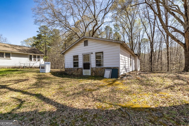 310 Austin Rd, Newnan, GA 30263 - view of side of home featuring a yard, stone siding, and an outbuilding