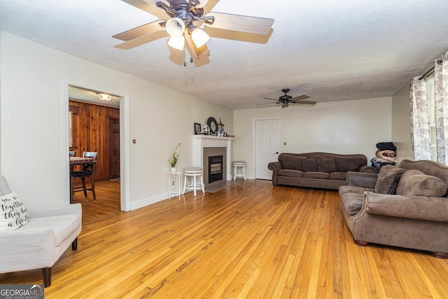 310 Austin Rd, Newnan, GA 30263 - living area featuring ceiling fan, light wood-type flooring, and a fireplace with flush hearth