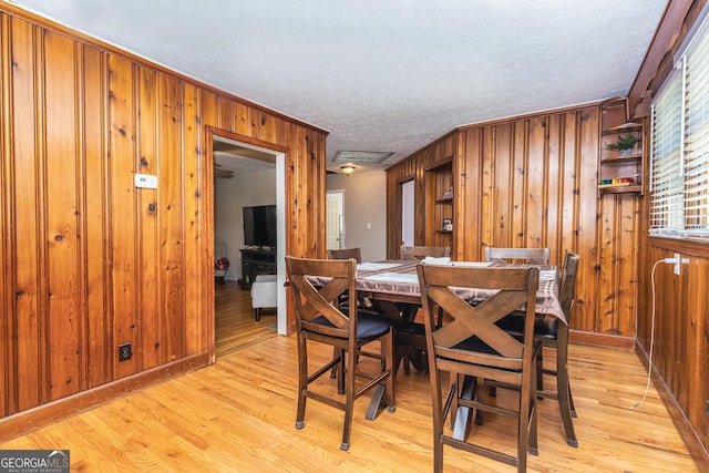 310 Austin Rd, Newnan, GA 30263 - dining room featuring wood walls, light wood-type flooring, and a textured ceiling
