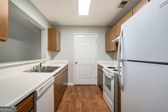 13304 Waldrop Cv, Decatur, GA 30034 - kitchen with light countertops, white appliances, dark wood-type flooring, a sink, and brown cabinetry