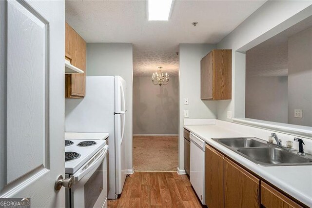 13304 Waldrop Cv, Decatur, GA 30034 - kitchen with light countertops, light wood-style flooring, white appliances, a sink, and brown cabinetry