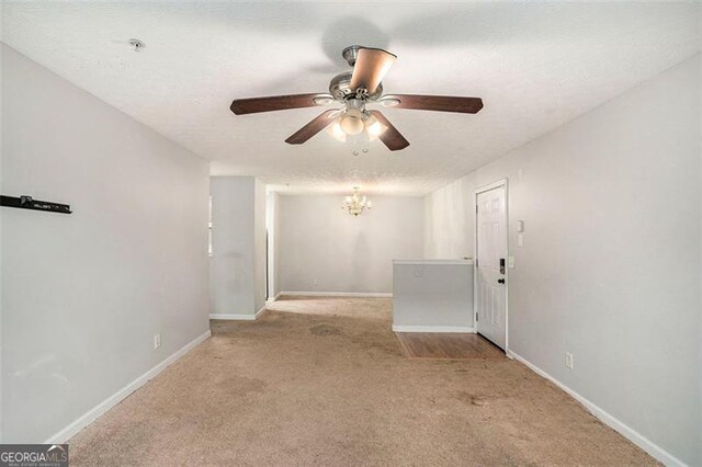 13304 Waldrop Cv, Decatur, GA 30034 - carpeted spare room featuring ceiling fan with notable chandelier, baseboards, and a textured ceiling
