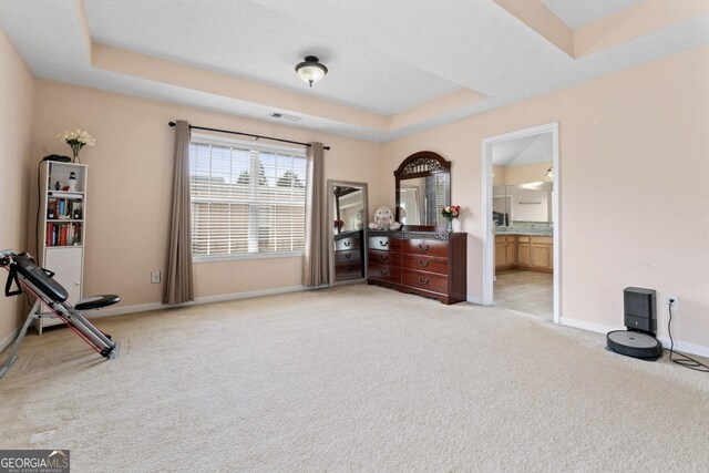 interior space featuring baseboards, visible vents, light carpet, and a raised ceiling
