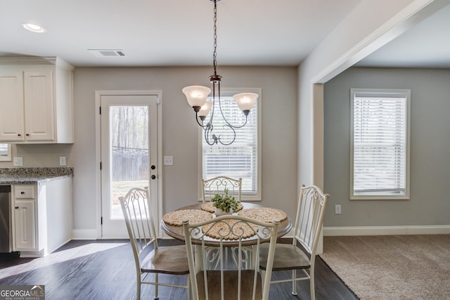 dining space featuring baseboards, a notable chandelier, visible vents, and a healthy amount of sunlight