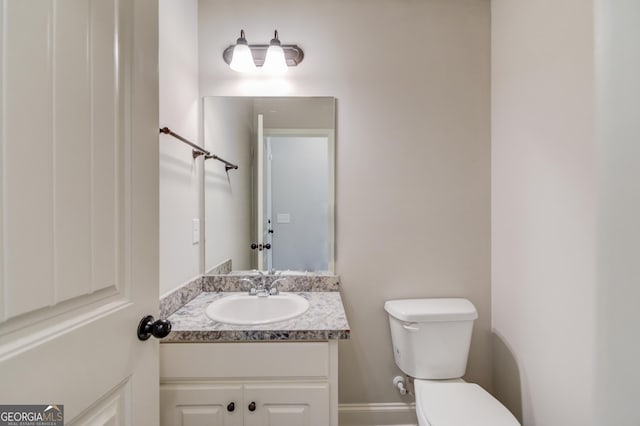 half bath featuring toilet and vanity