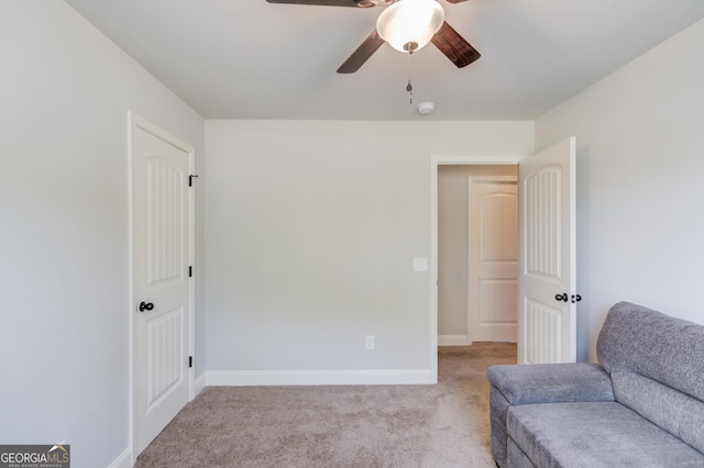 sitting room with carpet flooring, baseboards, and ceiling fan