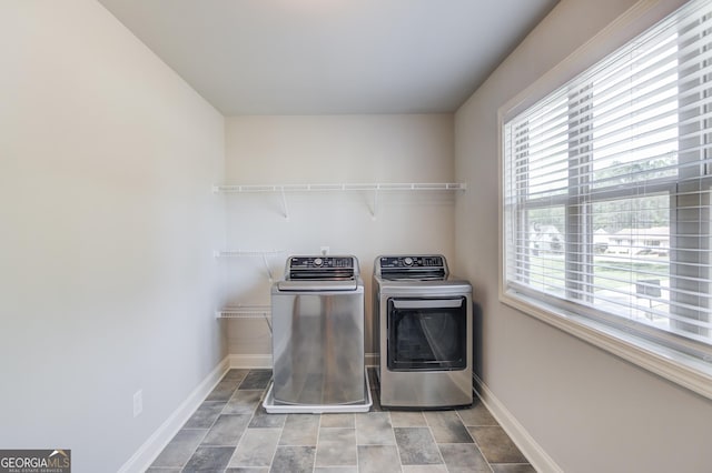 laundry room with baseboards, washer and dryer, and laundry area