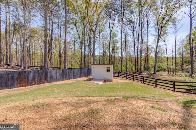 view of yard featuring an outbuilding, a storage unit, and a fenced backyard