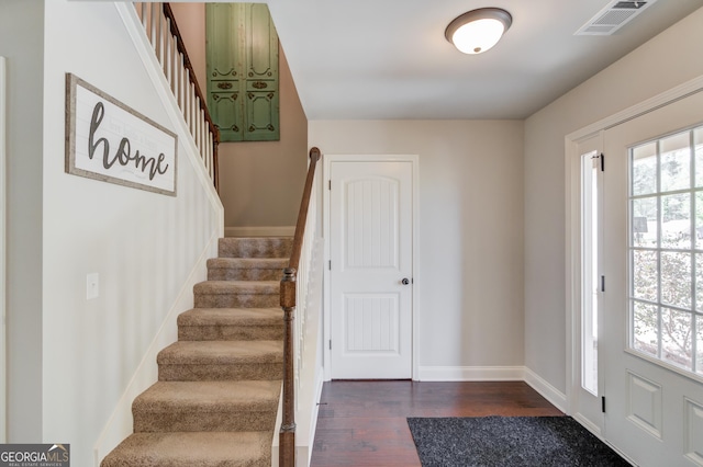 entrance foyer featuring dark wood-style flooring, a wealth of natural light, stairs, and visible vents