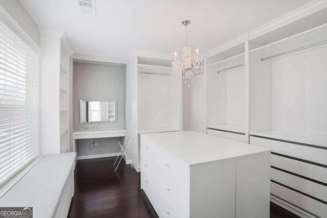 walk in closet featuring dark wood-style floors, visible vents, and a chandelier