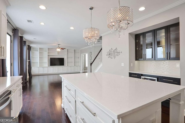 kitchen featuring dishwasher, light countertops, ceiling fan with notable chandelier, and dark wood finished floors