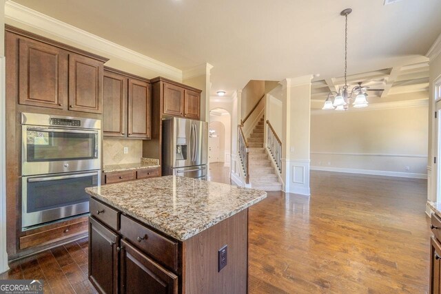 132 Windmeadow Way, Fayetteville, GA 30214 - kitchen with light stone countertops, stainless steel appliances, arched walkways, dark wood-type flooring, and an inviting chandelier