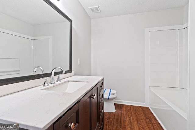 2199 Summertown Dr, Norcross, GA 30071 - full bath featuring vanity, wood finished floors, toilet, a textured ceiling, and shower / bathtub combination