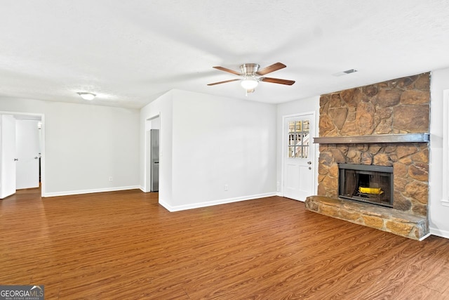 2199 Summertown Dr, Norcross, GA 30071 - unfurnished living room featuring wood finished floors, ceiling fan, a stone fireplace, and baseboards