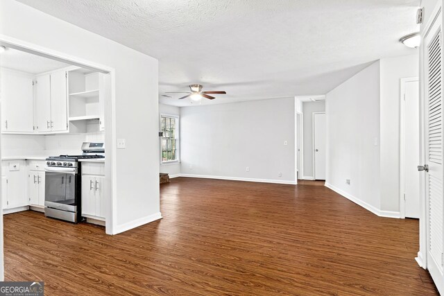 2199 Summertown Dr, Norcross, GA 30071 - kitchen featuring stainless steel gas stove, ceiling fan, dark wood-style flooring, white cabinets, and a textured ceiling