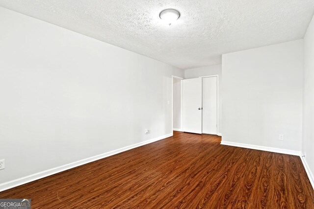 2199 Summertown Dr, Norcross, GA 30071 - unfurnished room with dark wood-type flooring, a textured ceiling, and baseboards
